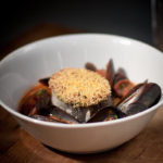 Polenta-crusted hake, mussels, chorizo & chickpeas